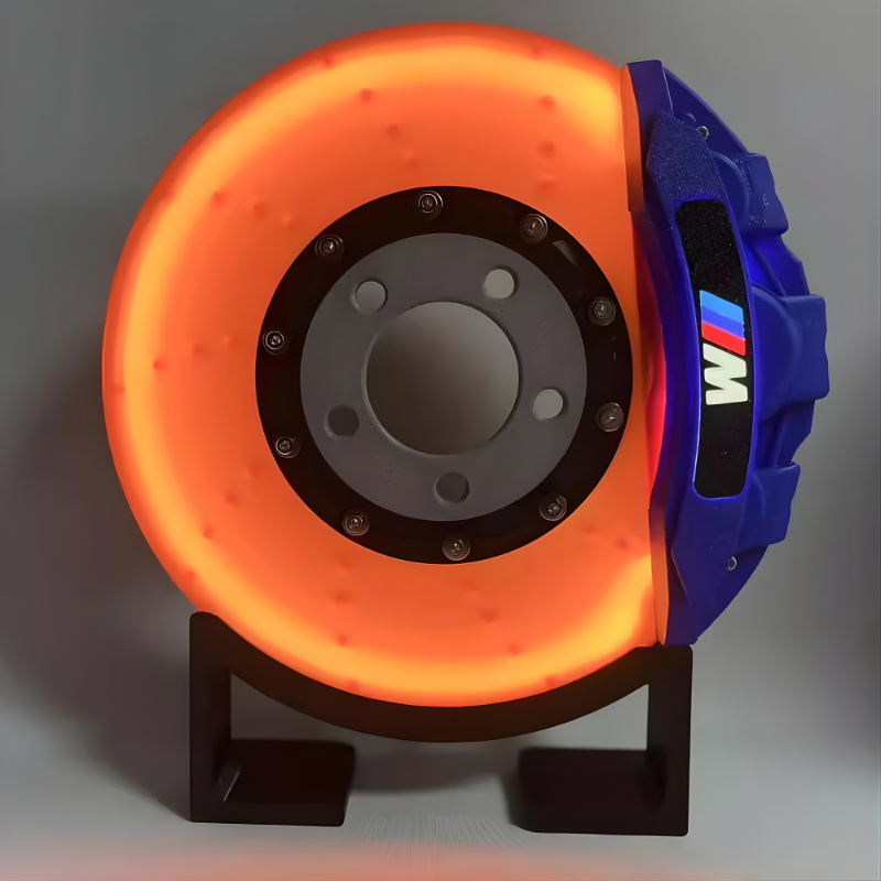 Orange and blue brake disc on a stand with BMW logo